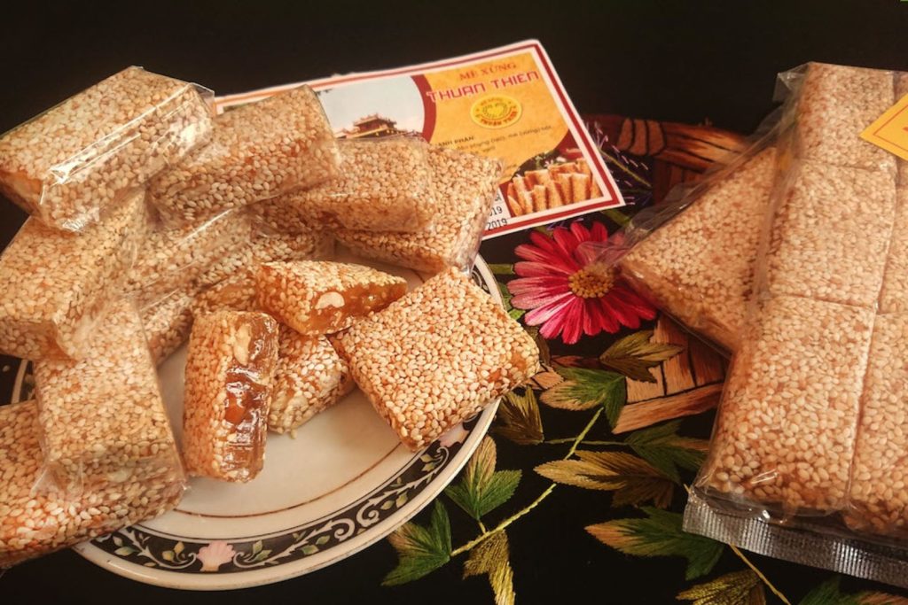 Packs of chewy sesame and peanut candy tied with colorful paper bands