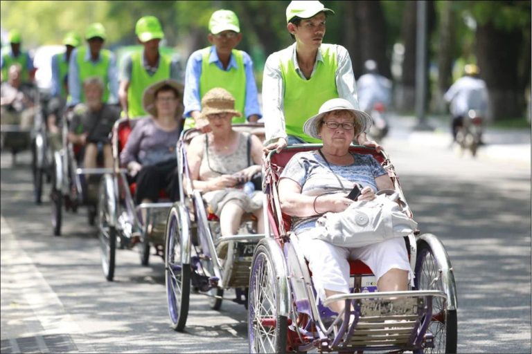 Tourists enjoy a hue cyclo ride through the ancient streets of Hue