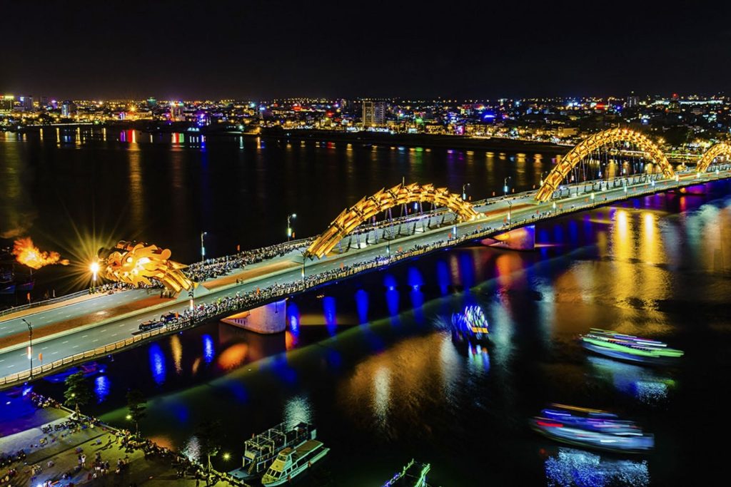 Da Nang's Dragon Bridge lit up at night and breathing fire over the Han River.