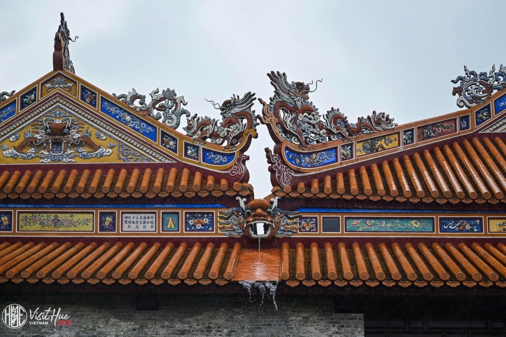 Nét chạm khắc rồng phượng tinh xảo trên mái ngói cổ kính trong mùa mưa du lịch Huế
