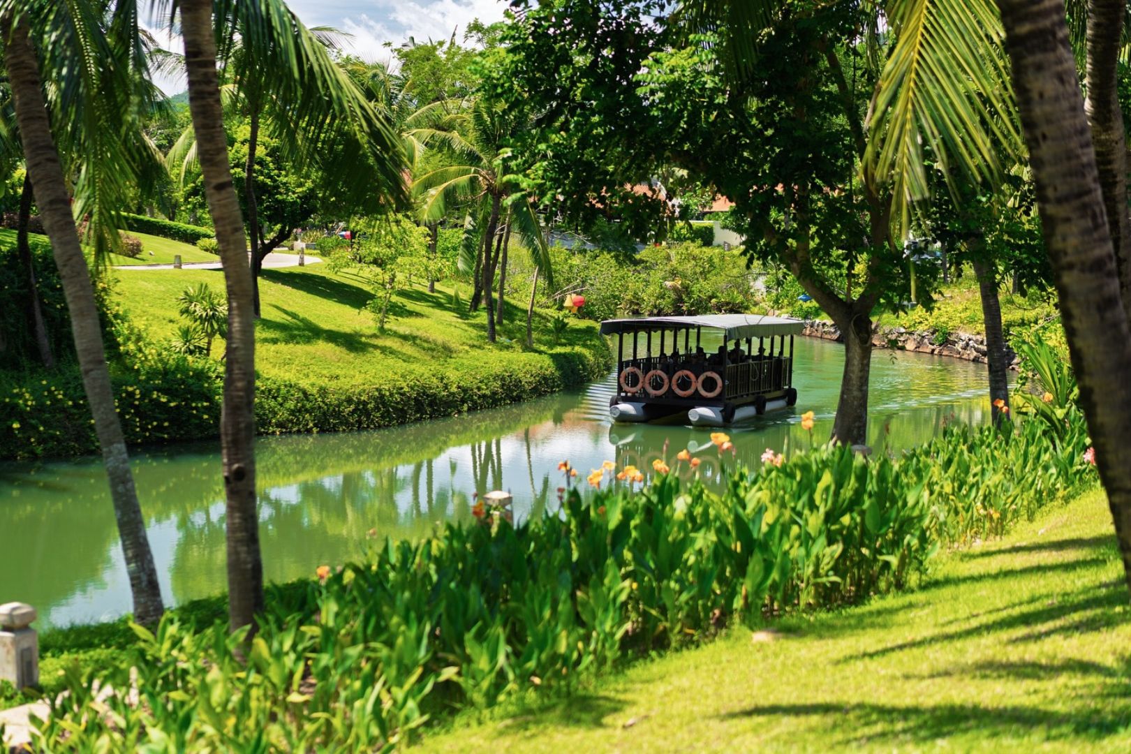 Shuttle boat cruising along the canal at Laguna Lăng Cô surrounded by tranquil greenery